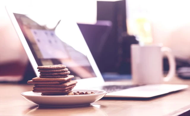 Stack of cookies and nuts beside a laptop, representing a balanced approach to website tracking and ePrivacy Regulation.
