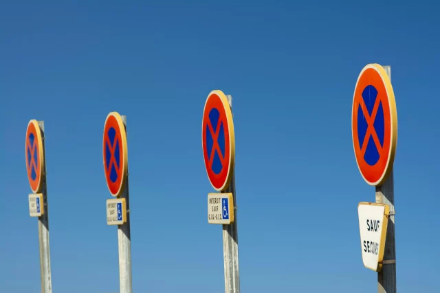 Four roadside "No Stopping" signs against a clear blue sky, illustrating strict compliance similar to ePrivacy Regulation.