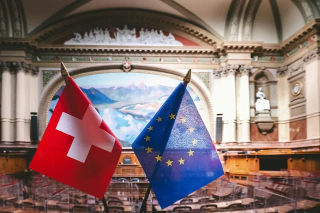 Swiss and European Union flags displayed in a legislative hall, as discussed in our Privacy Policy.