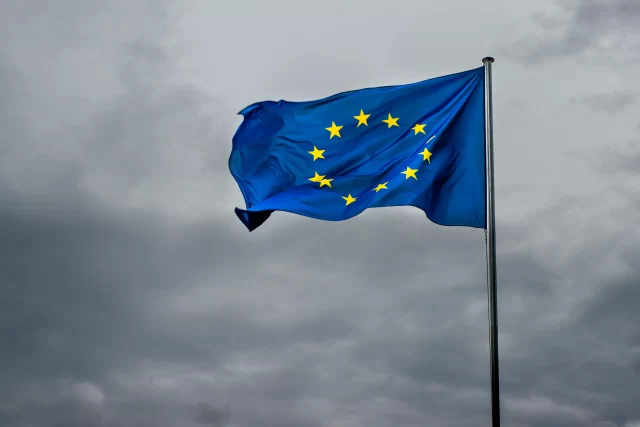 European Union flag waving against a cloudy sky, representing the jurisdictional reach of GDPR regulations.