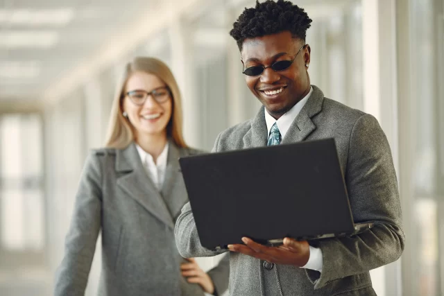 Business professionals collaborating on a DLP strategy while reviewing digital reports on a laptop.