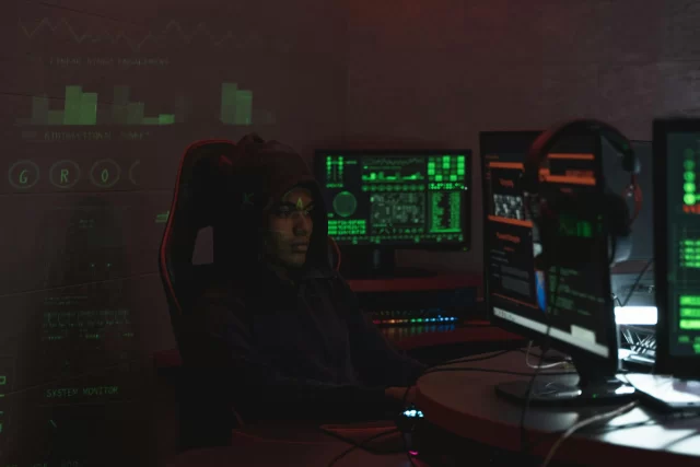 A professional in a hoodie monitors complex data streams and security analytics in a DPO automation environment.