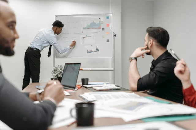 A diverse team holds a professional meeting to discuss data strategies and comply with Swiss GDPR.