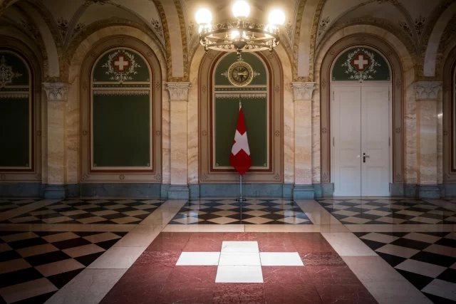 Swiss flag in a grand, stone-floored hall, illustrating institutional compliance regarding general data protection in Zürich.