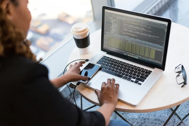 A software developer monitors code on a laptop screen to ensure general data protection in Zürich.