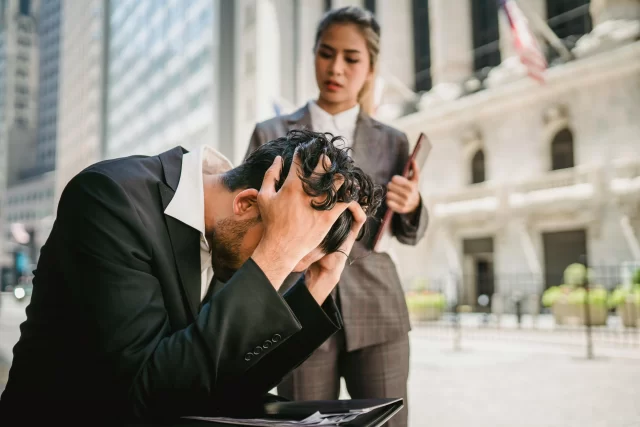 Stressed business professionals looking concerned over A Data Breach in front of a financial district building.