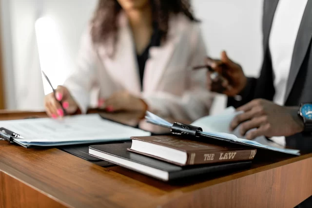 Legal professionals reviewing documents for Privacy P compliance at a desk.