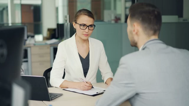 A professional recruiter interviewing a job candidate to discuss compliance with GDPR in Switzerland.